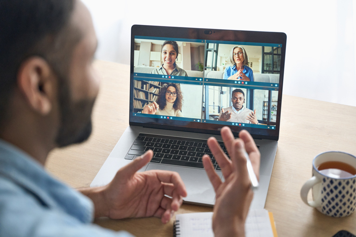Indian male coach on group call with other professional coaches.
