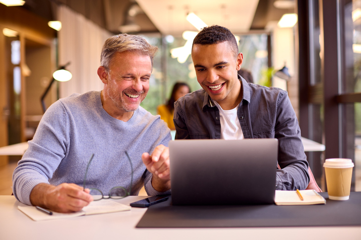 Mature male coach mentoring younger coach